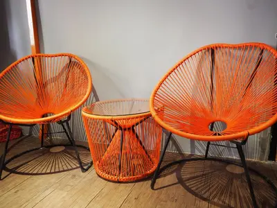 three orange chairs and a table in a room at Leo Backpackers @ Central Market in Kuala Lumpur