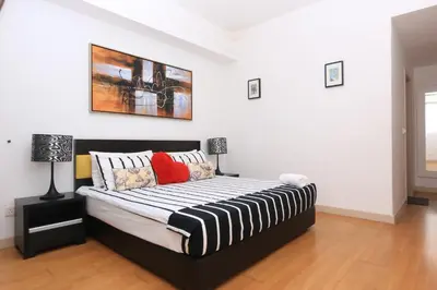 a bedroom with a large bed with two lamps at Suasana Bukit Ceylon Residence in Kuala Lumpur