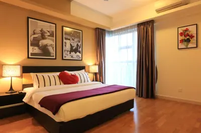 a bedroom with a large bed and a window at Suasana Bukit Ceylon Residence in Kuala Lumpur