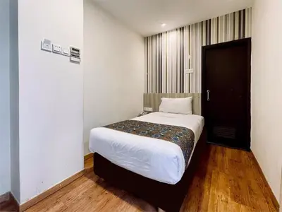 a bedroom with a large white bed and a black door at My Hotel @ Bukit Bintang in Kuala Lumpur