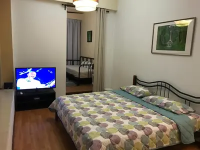 a bedroom with a bed and a flat screen tv at Parkview KLCC in Kuala Lumpur