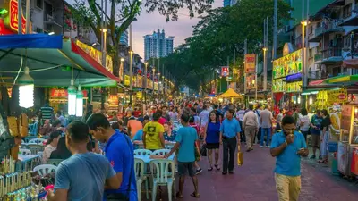 a crowd of people walking through a crowded street at night at Inspired Homes @ KLCC Soho Suite in Kuala Lumpur