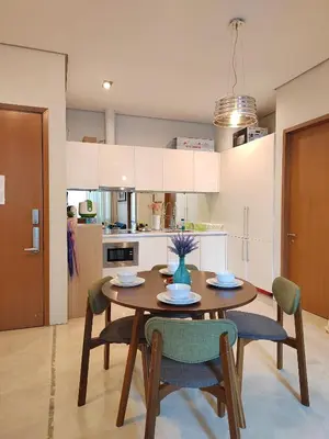 a kitchen and dining room with a wooden table and chairs at Inspired Homes @ KLCC Soho Suite in Kuala Lumpur