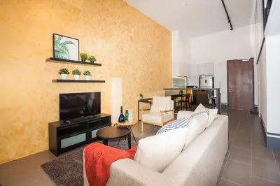 a living room with a couch and a television at The Establishment KL Sentral Bangsar by Plush in Kuala Lumpur