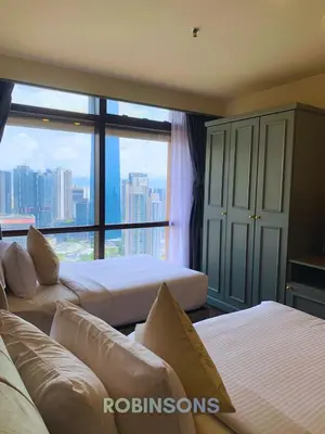 a hotel room with two beds and a large window at Robinsons at Times Square Kuala Lumpur in Kuala Lumpur