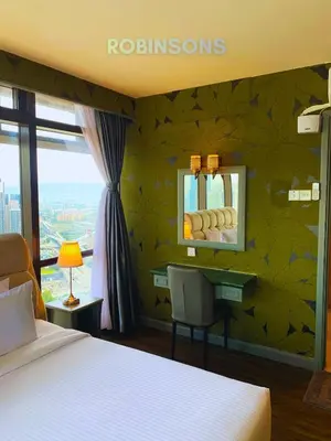 a bedroom with a bed and a desk with a mirror at Robinsons at Times Square Kuala Lumpur in Kuala Lumpur