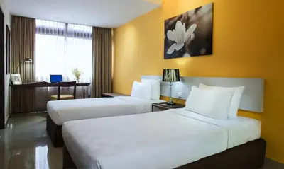 two beds in a hotel room with yellow walls at Fahrenheit Suites Bukit Bintang, Kuala Lumpur in Kuala Lumpur