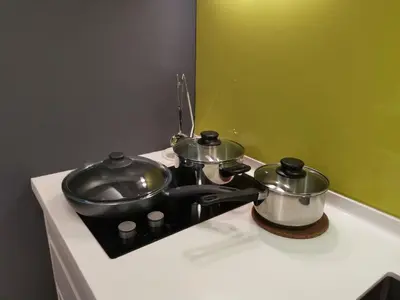 two pots and pans sitting on top of a stove at The Signature Serviced Suites Kuala Lumpur in Kuala Lumpur