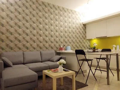 a living room with a couch and a table and a kitchen at The Signature Serviced Suites Kuala Lumpur in Kuala Lumpur