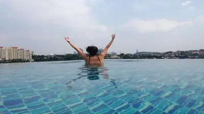 a woman in a pool with her arms in the water at The Signature Serviced Suites Kuala Lumpur in Kuala Lumpur