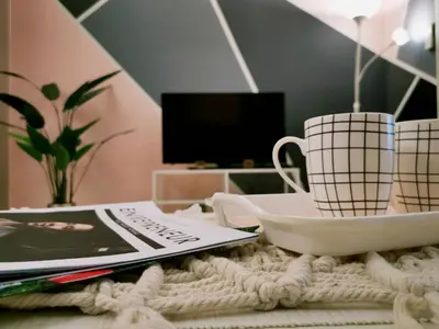 a table with two cups and a plate and a magazine at The Signature Serviced Suites Kuala Lumpur in Kuala Lumpur