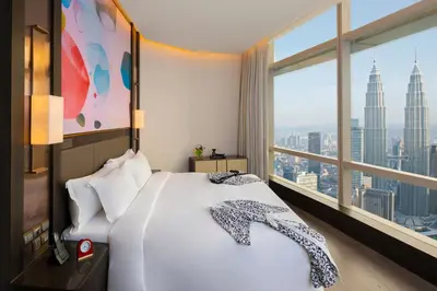 a bedroom with a large bed and a large window at Banyan Tree Kuala Lumpur in Kuala Lumpur