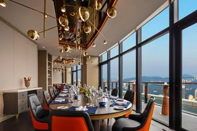 a dining room with a table and chairs and windows at Banyan Tree Kuala Lumpur in Kuala Lumpur