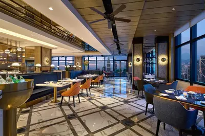 a restaurant with tables and chairs and windows at Banyan Tree Kuala Lumpur in Kuala Lumpur