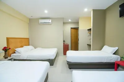 a hotel room with two beds and a tv at Hotel Raja Bot in Kuala Lumpur