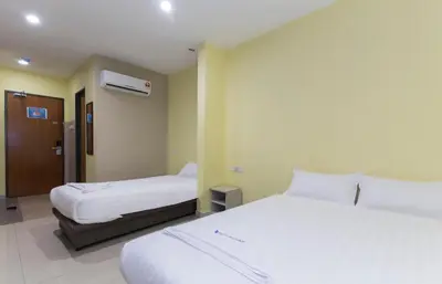 a hotel room with two beds and a bathroom at Hotel Raja Bot in Kuala Lumpur