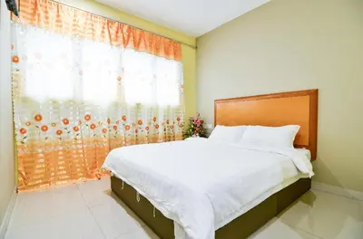 a bedroom with a large bed and a window at Hotel Raja Bot in Kuala Lumpur