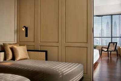 a bedroom with a bed and a table and a chair at The RuMa Hotel and Residences in Kuala Lumpur