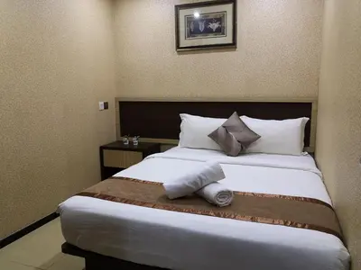 a hotel room with a large bed with pillows at Hotel Grand Palace Ampang in Ampang