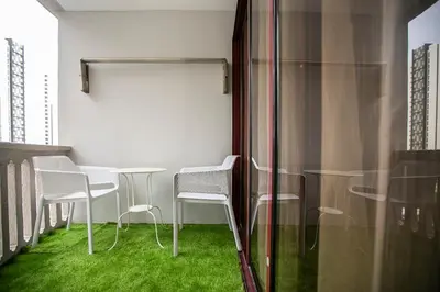 a table and chairs on a balcony with green grass at The Forum Condominium by LaFabrica in Kuala Lumpur