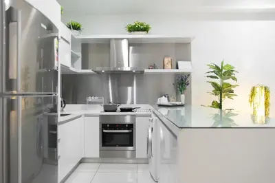 a white kitchen with a stove and a refrigerator at Mcity Jalan Ampang in Kuala Lumpur