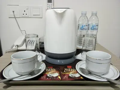 a table with two cups and a blender and water bottles at CITI HOTEL @ KL SENTRAL in Kuala Lumpur