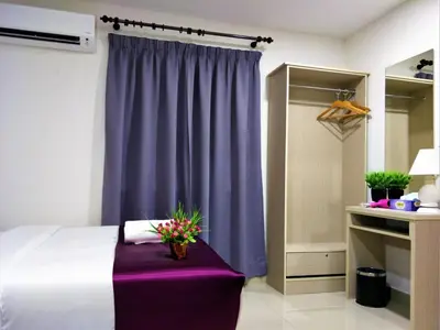 a bedroom with a purple curtain and a bed with a purple bench at CITI HOTEL @ KL SENTRAL in Kuala Lumpur
