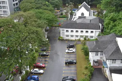 a group of cars parked in a parking lot in front of a church at Holiday Paradise in Kuala Lumpur