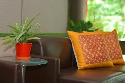 a potted plant sitting on a table next to a chair at The Maple Suite in Kuala Lumpur