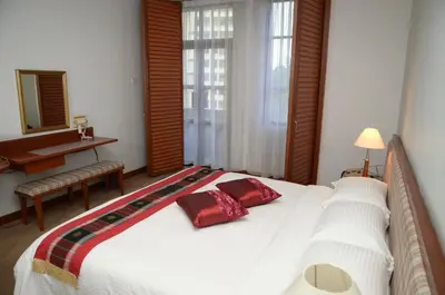a bedroom with a large white bed with red pillows at The Maple Suite in Kuala Lumpur