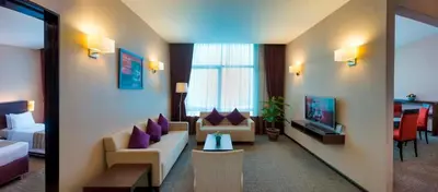 a hotel room with a couch and a tv at Furama Bukit Bintang, Kuala Lumpur in Kuala Lumpur