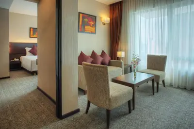 a hotel room with a bed and a table and chairs at Furama Bukit Bintang, Kuala Lumpur in Kuala Lumpur