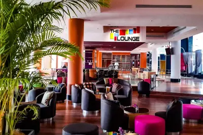 a lobby with chairs and plants in a building at Wyndham Grand Bangsar Kuala Lumpur in Kuala Lumpur
