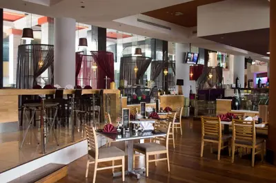 a restaurant with tables and chairs and a bar at Wyndham Grand Bangsar Kuala Lumpur in Kuala Lumpur
