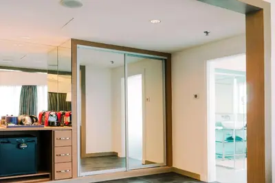 a room with a mirror and a dresser in a room at Wyndham Grand Bangsar Kuala Lumpur in Kuala Lumpur