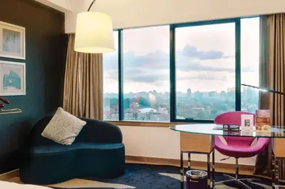 a room with a table and a chair and a window at Wyndham Grand Bangsar Kuala Lumpur in Kuala Lumpur