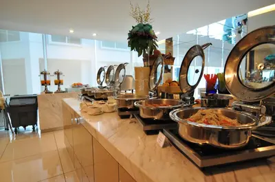 a buffet with many bowls of food on a counter at Damas Suites & Residences Kuala Lumpur in Kuala Lumpur
