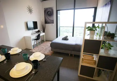 a living room with a dining table and a bed at KL Sentral, EST Bangsar by SkyLimit Suites in Kuala Lumpur