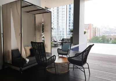 a room with chairs and a couch on a balcony at KL Sentral, EST Bangsar by SkyLimit Suites in Kuala Lumpur