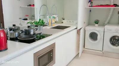 a kitchen with a sink and a washing machine at Soho Suites KLCC by Elite in Kuala Lumpur