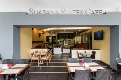 a restaurant with wooden tables and chairs and a kitchen at 3 Bedroom Cozy apartmet in Kuala Lumpur