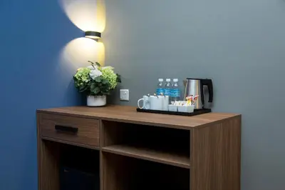 a table with a coffee maker and a plant on it at Imperial Regency Suites & Kuala Lumpur in Kuala Lumpur