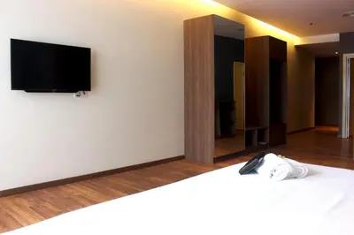 a bedroom with a bed with a tv on the wall at Imperial Regency Suites & Kuala Lumpur in Kuala Lumpur