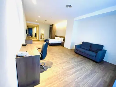 a room with a desk and a couch and a bed at Imperial Regency Suites & Kuala Lumpur in Kuala Lumpur