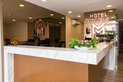 a hotel lobby with a reception counter with flowers at Double M Hotel @ Kl Sentral in Kuala Lumpur