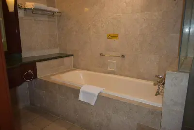 a bathroom with a bath tub with a towel on it at Grand Service Apartment @ Times Square in Kuala Lumpur
