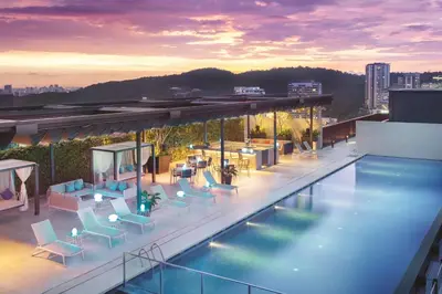 a swimming pool with chairs and tables on a building at Hyatt House Kuala Lumpur, Mont Kiara in Kuala Lumpur