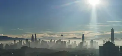 a city skyline with the sun in the sky at Hyatt House Kuala Lumpur, Mont Kiara in Kuala Lumpur
