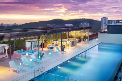 a swimming pool with chairs and tables on a building at Hyatt House Kuala Lumpur, Mont Kiara in Kuala Lumpur