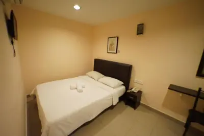 a bedroom with a bed with two candles on it at Hotel A-One in Kuala Lumpur